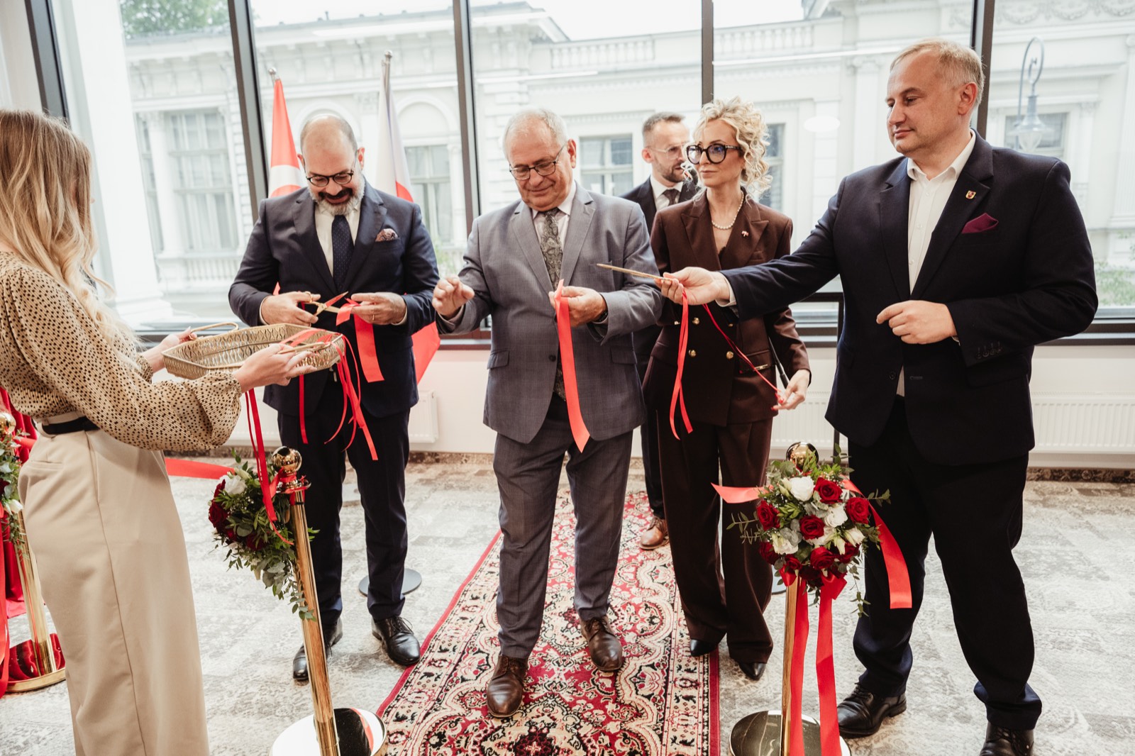 Goście honorowi trzymający wstęgę podczas ceremonii otwarcia konsulatu